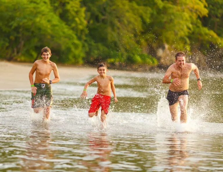 2 kids and his father running in a beach for Family Vacation in Costa Rica